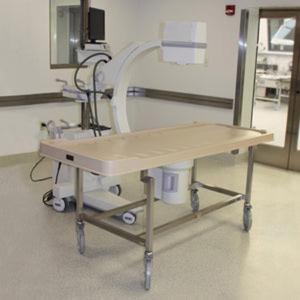 C-arm accessible autopsy carrier with plastic tray